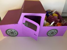 a purple cardboard toy truck with its door open