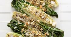 grilled lettuce topped with parmesan cheese and nuts on a white platter