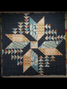 a quilted wall hanging with an abstract design on it's side and the bottom half