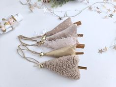 four different types of hair pins on top of a white table next to christmas decorations