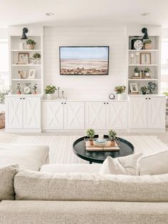 a living room filled with furniture and a flat screen tv mounted to the side of a wall