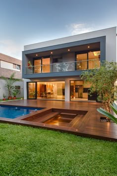 a modern house with a swimming pool in the yard and decked grass around it