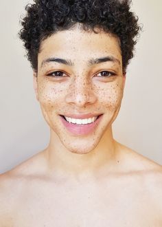 a young man with freckles on his face and chest smiling at the camera