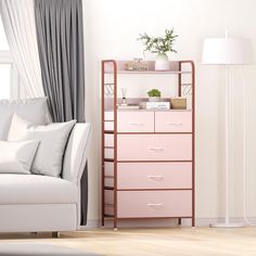 a living room with a white couch and pink dresser