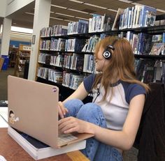 a woman sitting in front of a laptop wearing headphones