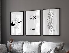 three black and white posters on the wall above a couch