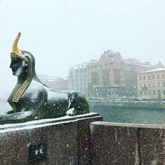 an image of a statue in the middle of winter with snow falling on it's ground