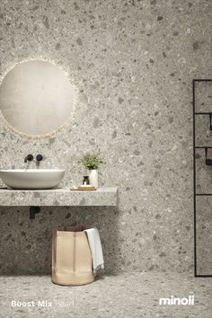 a bathroom sink sitting under a mirror next to a white vase and potted plant