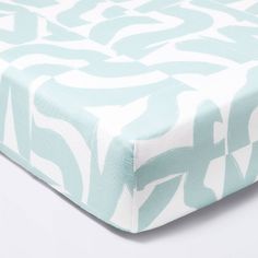 a baby crib sheet with blue and white designs on it's coverlet