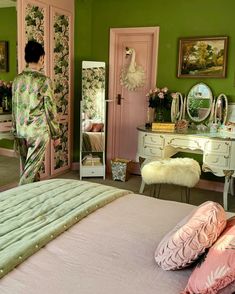 a bedroom with pink and green walls, white dressers, and an open closet