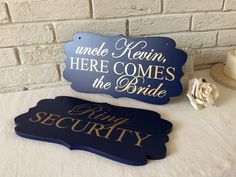 there are two signs that say here comes the bride and king security on top of a table