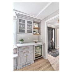 a kitchen with gray cabinets and white counter tops, along with an oven in the center