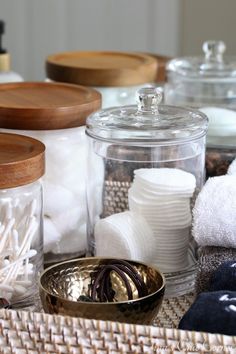 several jars and bowls are stacked on top of each other, with towels in them