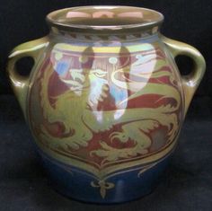 a ceramic vase with dragon designs painted on the outside and inside, sitting on a black surface