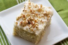 a white plate topped with a piece of cake on top of a green table cloth