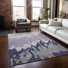 a living room filled with furniture and a large rug on top of a hard wood floor