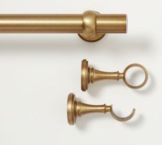 two brass curtain rods with handles and hooks