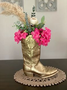 a gold cowboy boot with pink flowers in it