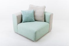 a light blue and white chair with pillows on the armrests, against a white background