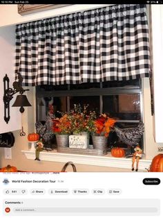 a kitchen window decorated for fall with pumpkins and flowers