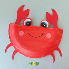 a red paper plate with a crab on it's face and eyes painted onto the side