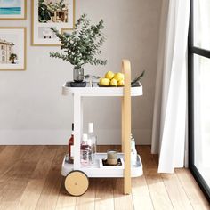 a white cart with lemons and other items on it in front of a window