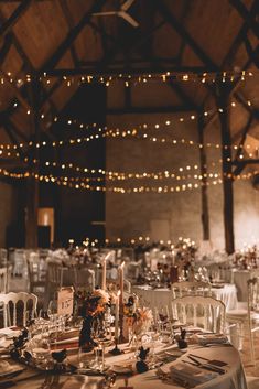 the tables are set with white linens and silverware for an elegant wedding reception