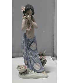 a figurine of a woman with flowers in her hair and holding a flower