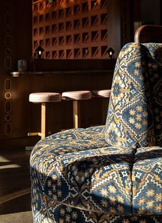 an upholstered chair sits in front of several stools