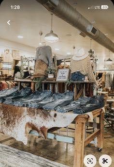 a cow hide in the middle of a shop with jeans on display and other items for sale