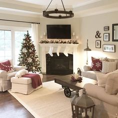 a living room filled with furniture and a christmas tree in front of a fire place