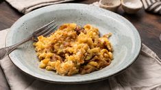 a white bowl filled with macaroni and cheese on top of a wooden table