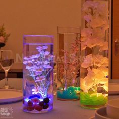 three vases filled with flowers sitting on top of a table