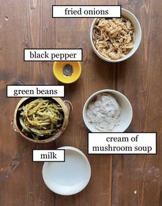 four bowls with different types of food in them on a wooden table next to each other