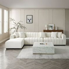 a living room with white furniture and wood flooring