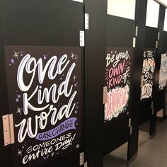 a row of black urinals with writing on them