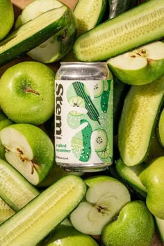 an apple and cucumber drink surrounded by sliced up green apples in a pile