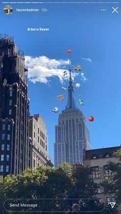 there are many kites flying in the sky near tall buildings on this sunny day