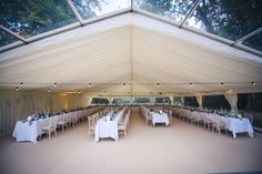 the inside of a tent with tables and chairs