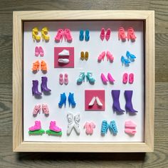 a shadow box with various pairs of shoes and socks in it on a wooden surface