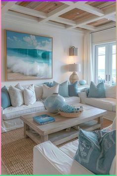 a living room filled with white couches and blue pillows on top of each other