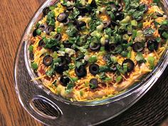 a pizza sitting on top of a metal pan covered in olives and green peppers