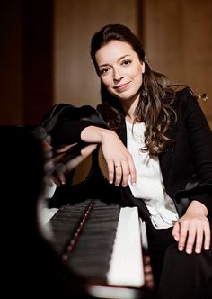 a woman sitting at a piano posing for the camera