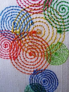 the screen is showing an image of colorful circles on white fabric with red, green, blue and yellow thread