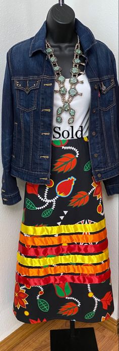 a dress and jean jacket on display in a shop window, with the name sold written on it