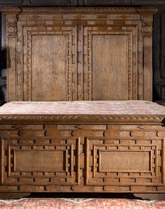 an old wooden bed with intricate carvings on the headboard