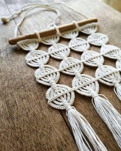 a piece of white string with tassels on it sitting on top of a wooden table