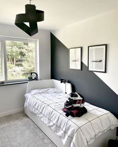 a bedroom with black and white decor in the corner, two framed pictures on the wall