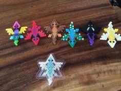 six different colored snowflakes on a wooden table