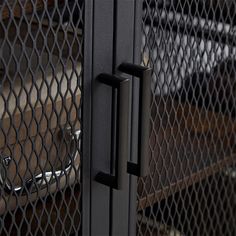 a close up of a metal door with a chain link fence around it and an open handle on the side